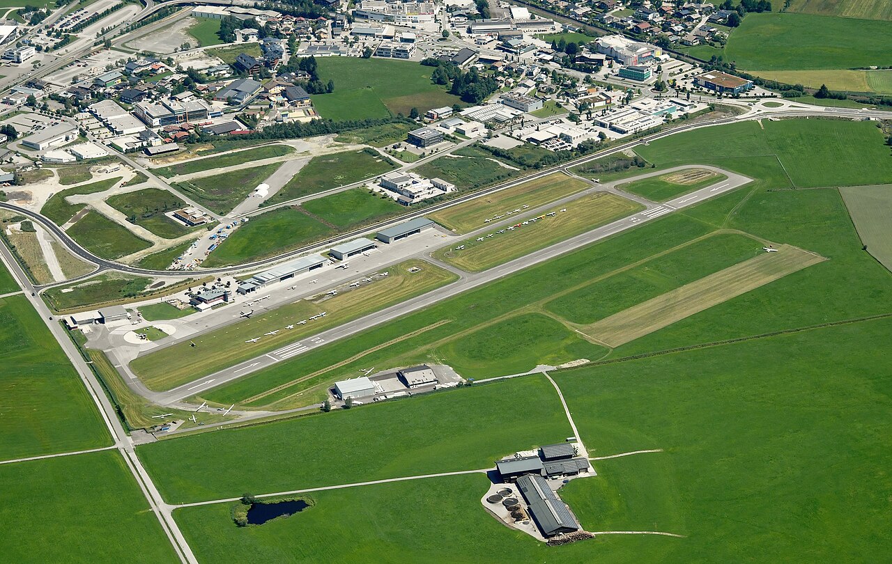 Luftbild des Flugplatzes Zell am See mit Piste und Alpenraum